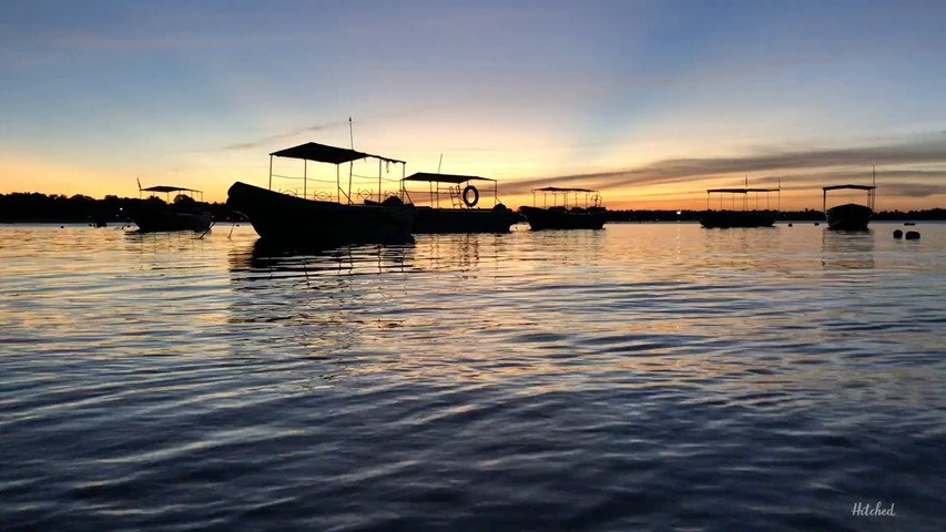 Silhouette of boats floating in a scenic sunset 