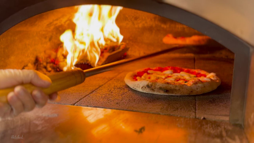 Turning some pizzas in the woodfired oven